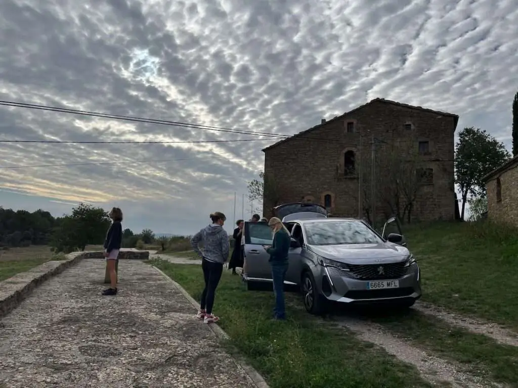 Deelnemers met auto bij huis in Linya.