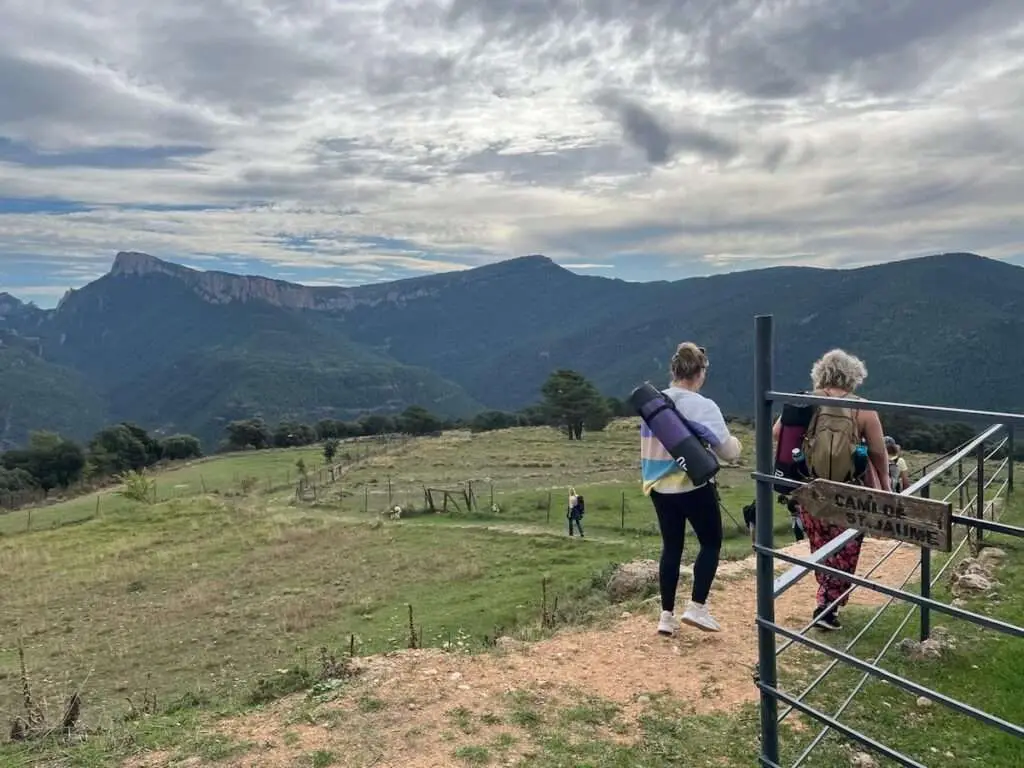 Deelnemers wandelen in een bergachtige omgeving.