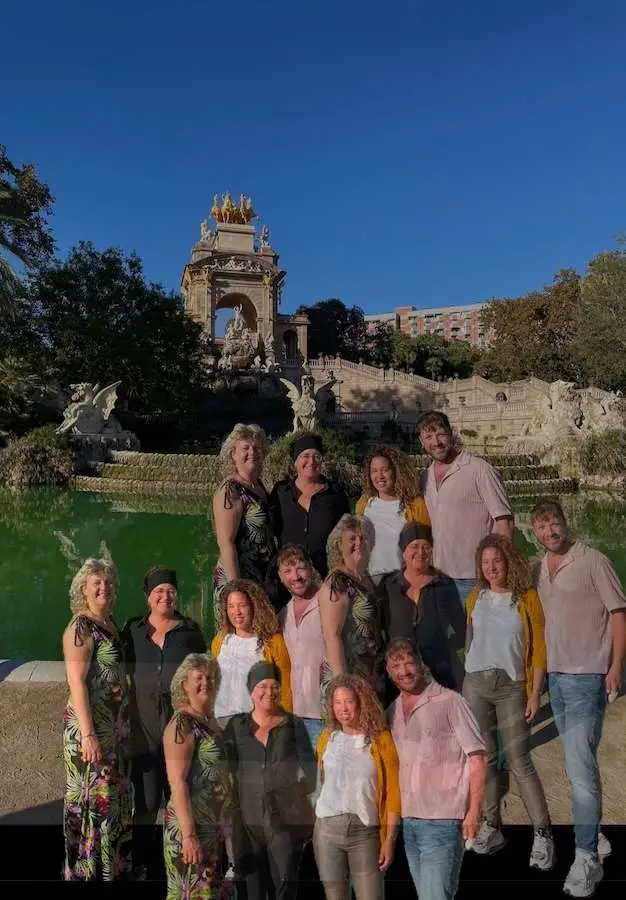 Deelnemers poseren samen in Barcelona met gebouw op achtergrond.