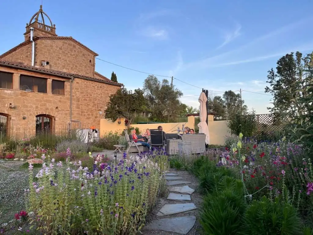 Deelnemers op terras bij energetische tuin met edelstenen.