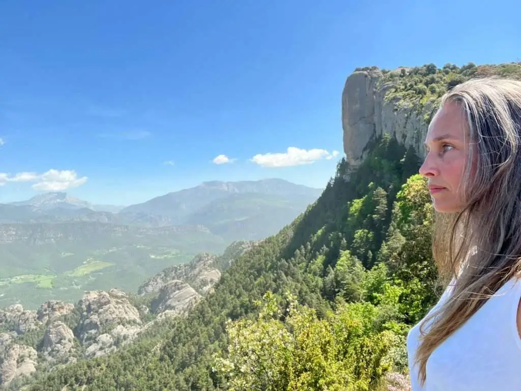 Deelnemer op uitzichtpunt met rots naast zich.