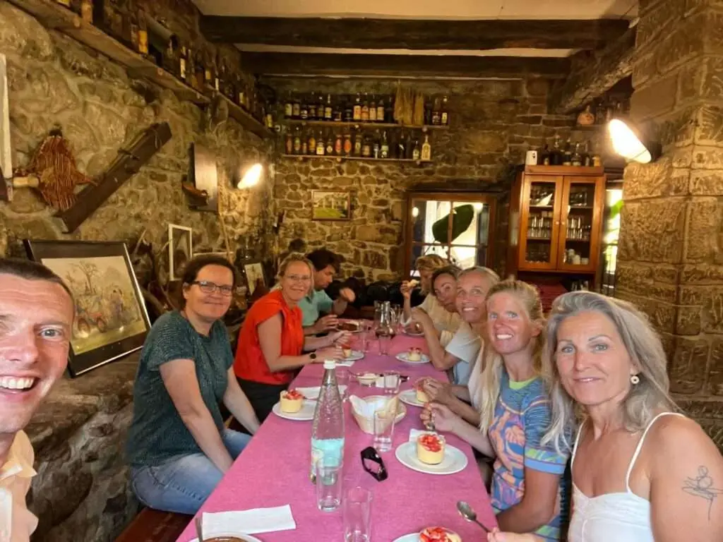 Groep deelnemers die samen dineert in een Catalaans familierestaurant tijdens de healing holiday.