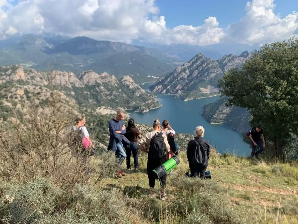 Groep deelnemers die samen door de berglandschappen wandelt.